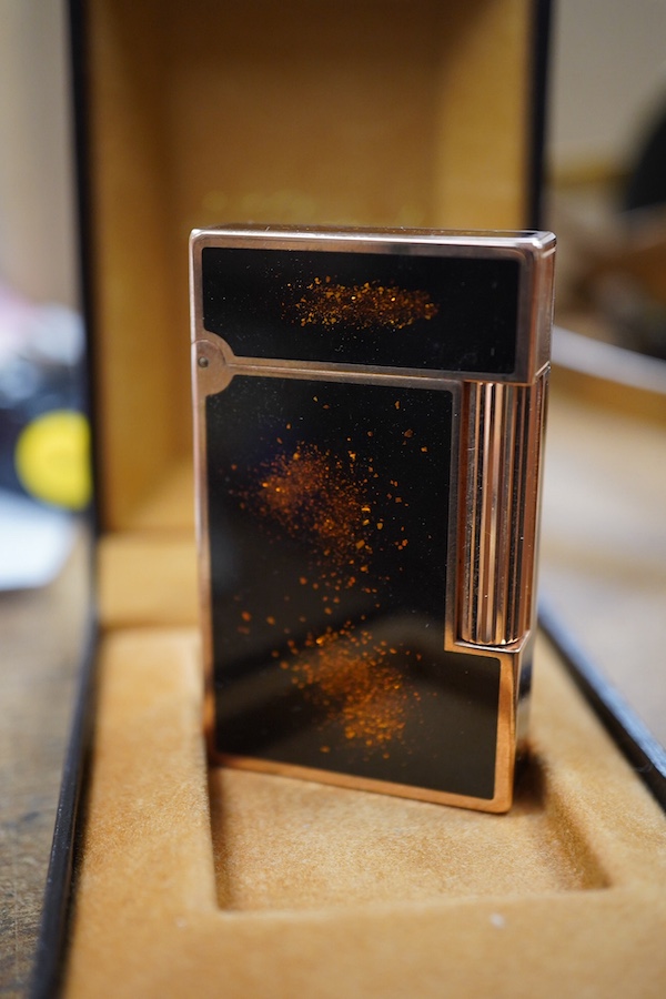 A cased Dupont 'gold dust' lighter with booklet. 6.3cm high. Condition - good
